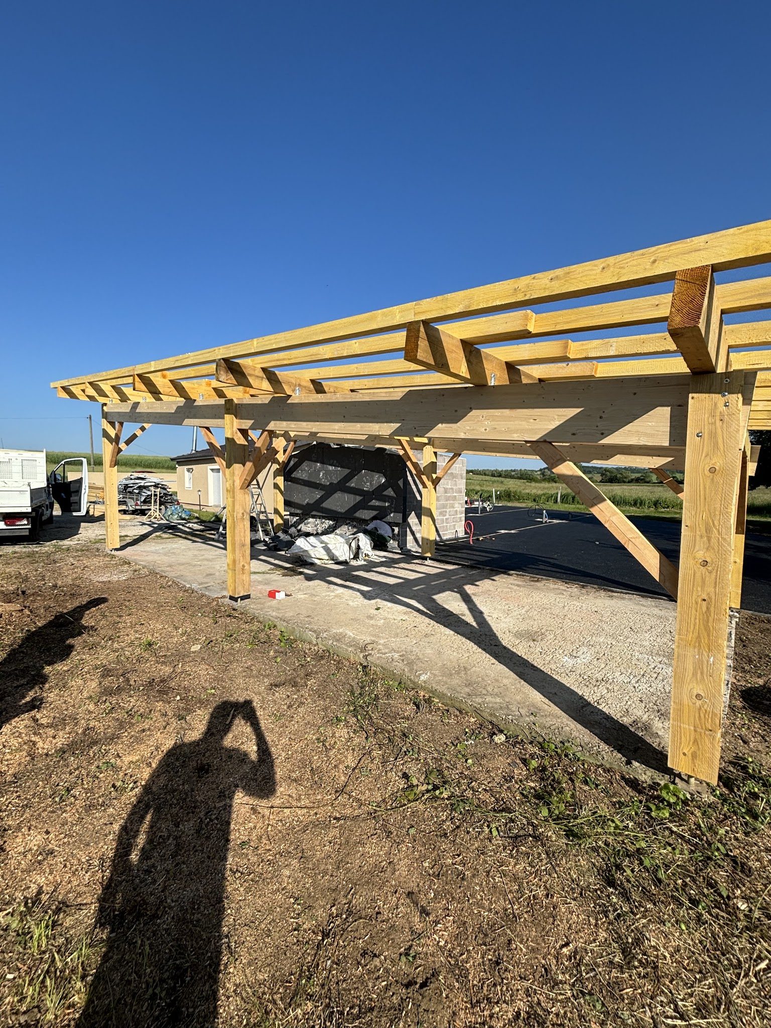 Charpente en bois d'un carport sous un ciel bleu